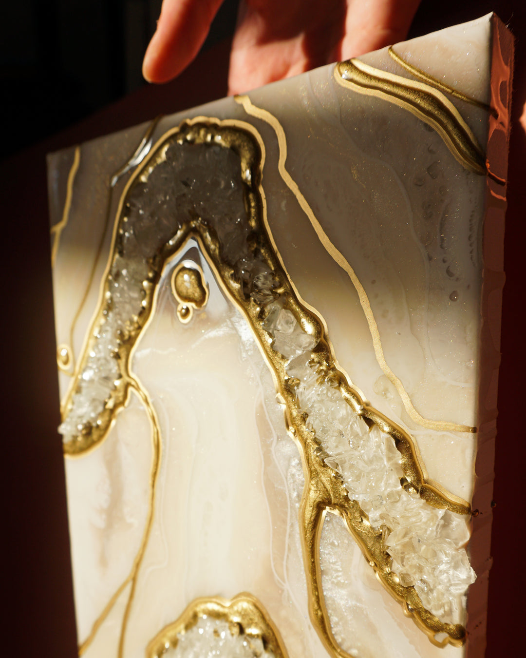 Epoxy resin being poured onto a canvas, creating fluid abstract art