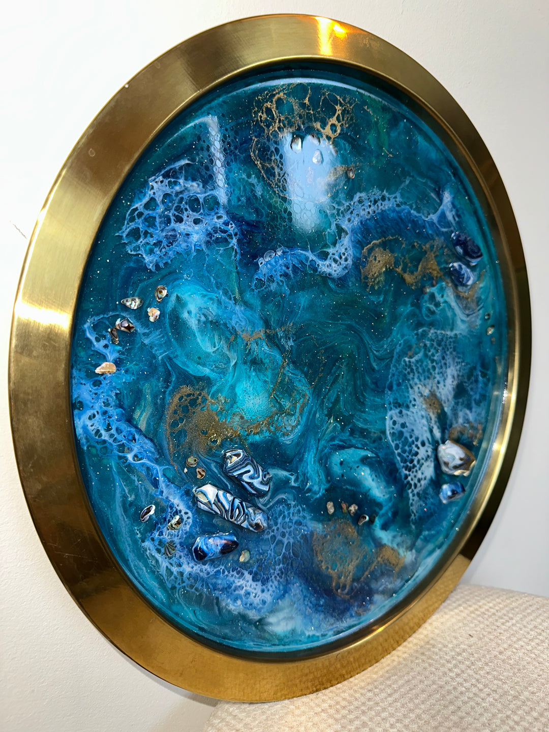 Round artwork with blue and gold design on a white background